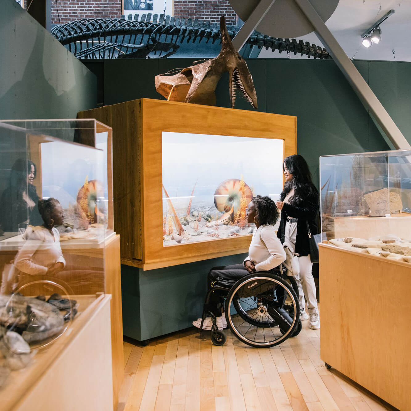 Two women, one in a wheel chair enjoying museum exhibits together